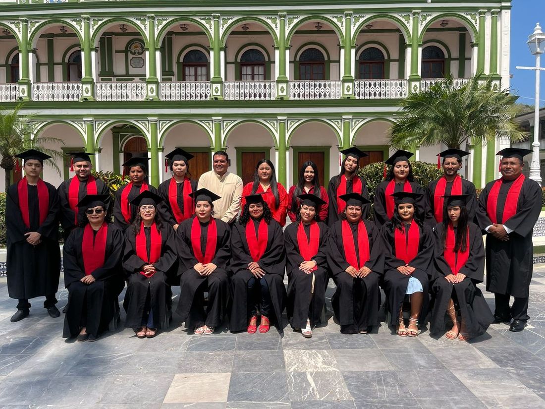 Generación de egresados de Prepa12 en su ceremonia de graduación, con toga y birrete, frente al Palacio Municipal